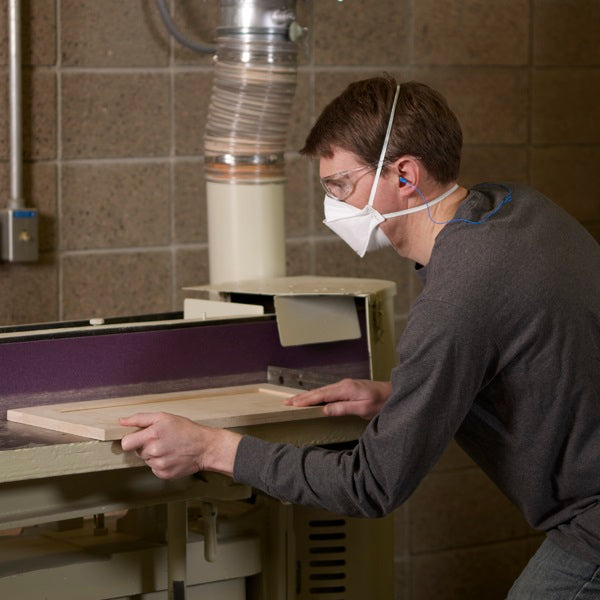 Man wearing 3M Canada 9210+ Aura N95 respirator mask in workshop for dust cutting wood