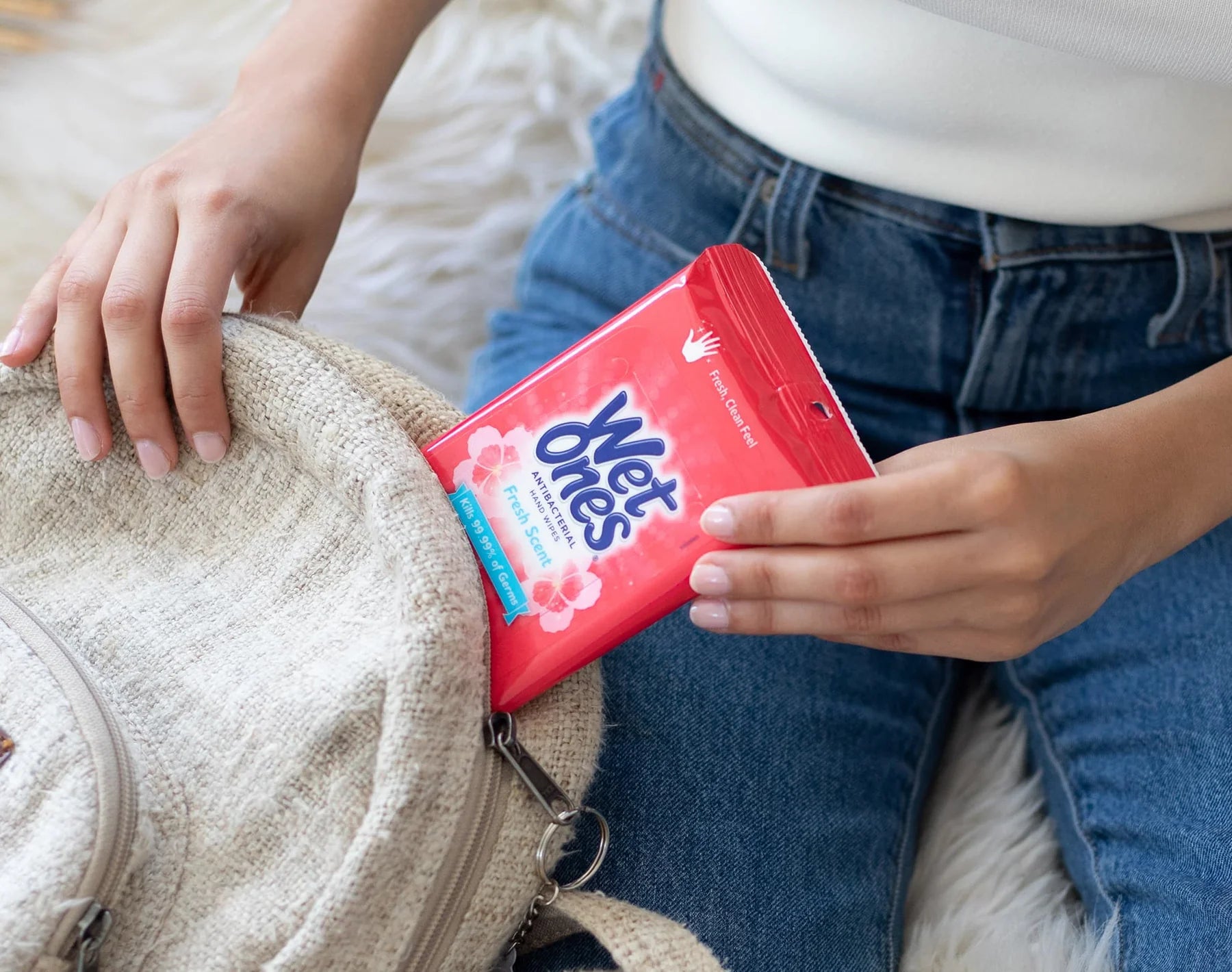 Canadian woman packing wet ones antibacterial wipes into purse backpack